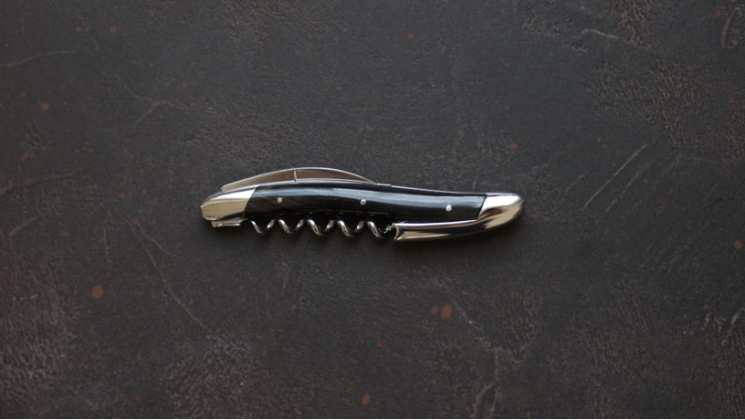Sacacorchos Sommelier Forge De Laguiole con acabado cuerno oscuro y alto brillo.